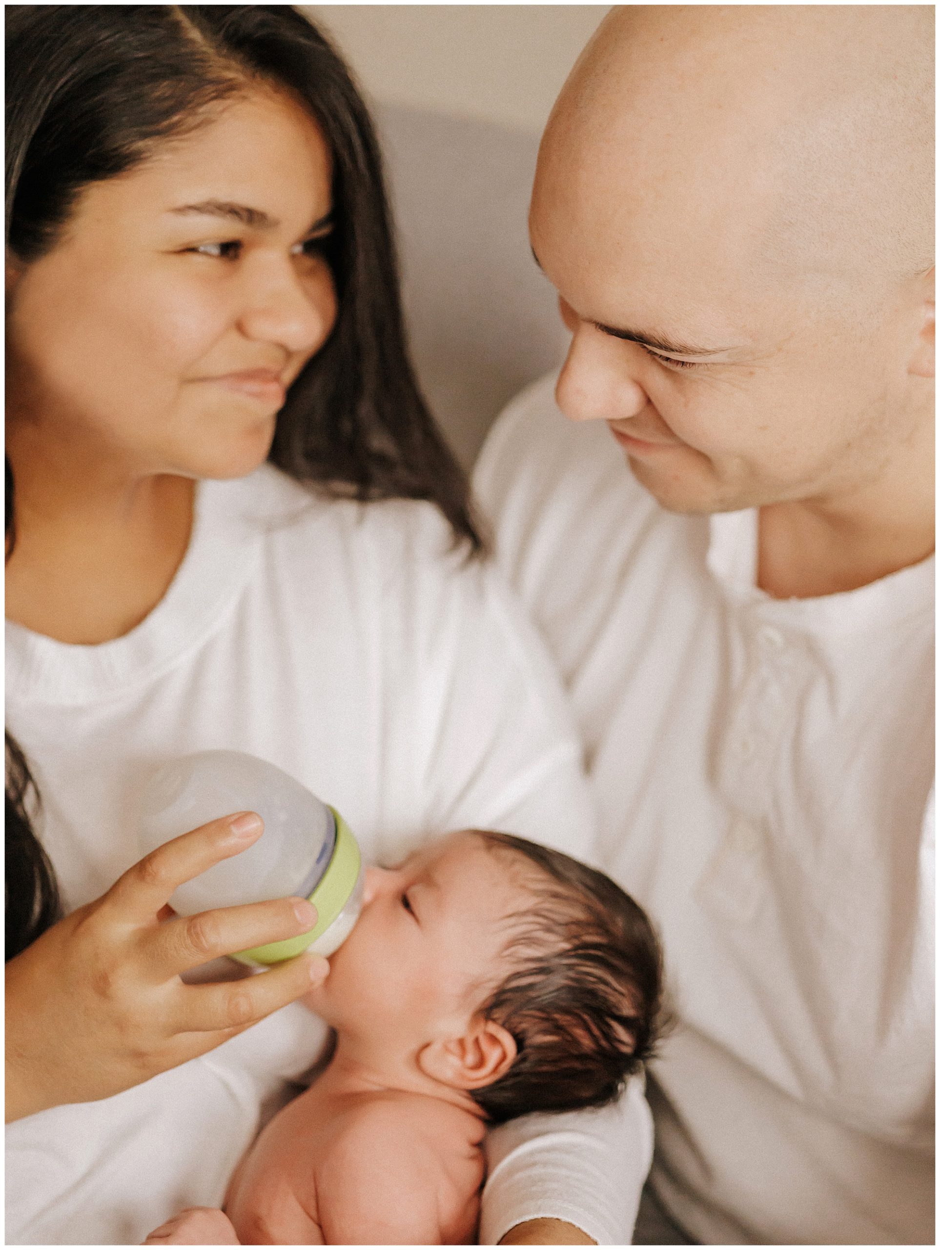 New mom and dad bottle feeding newborn baby boy during lifestyle in home session in Murfreesboro TN