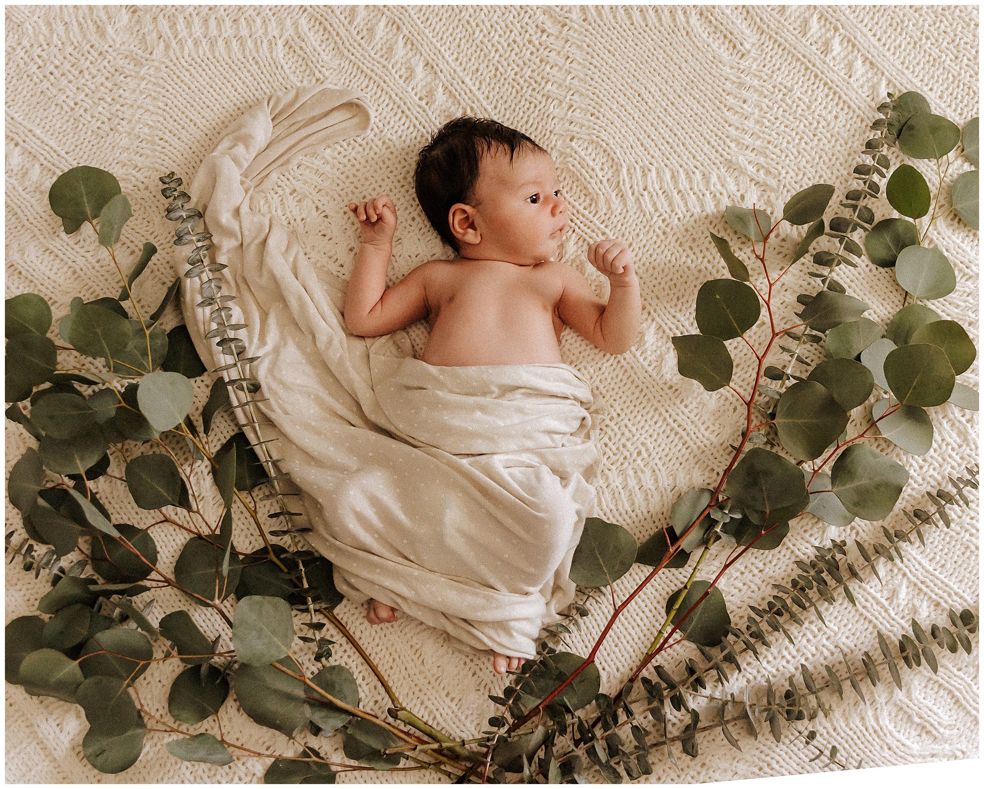 Newborn Baby Boy with Eucalyptus branches during lifestyle newborn session in murfreesboro