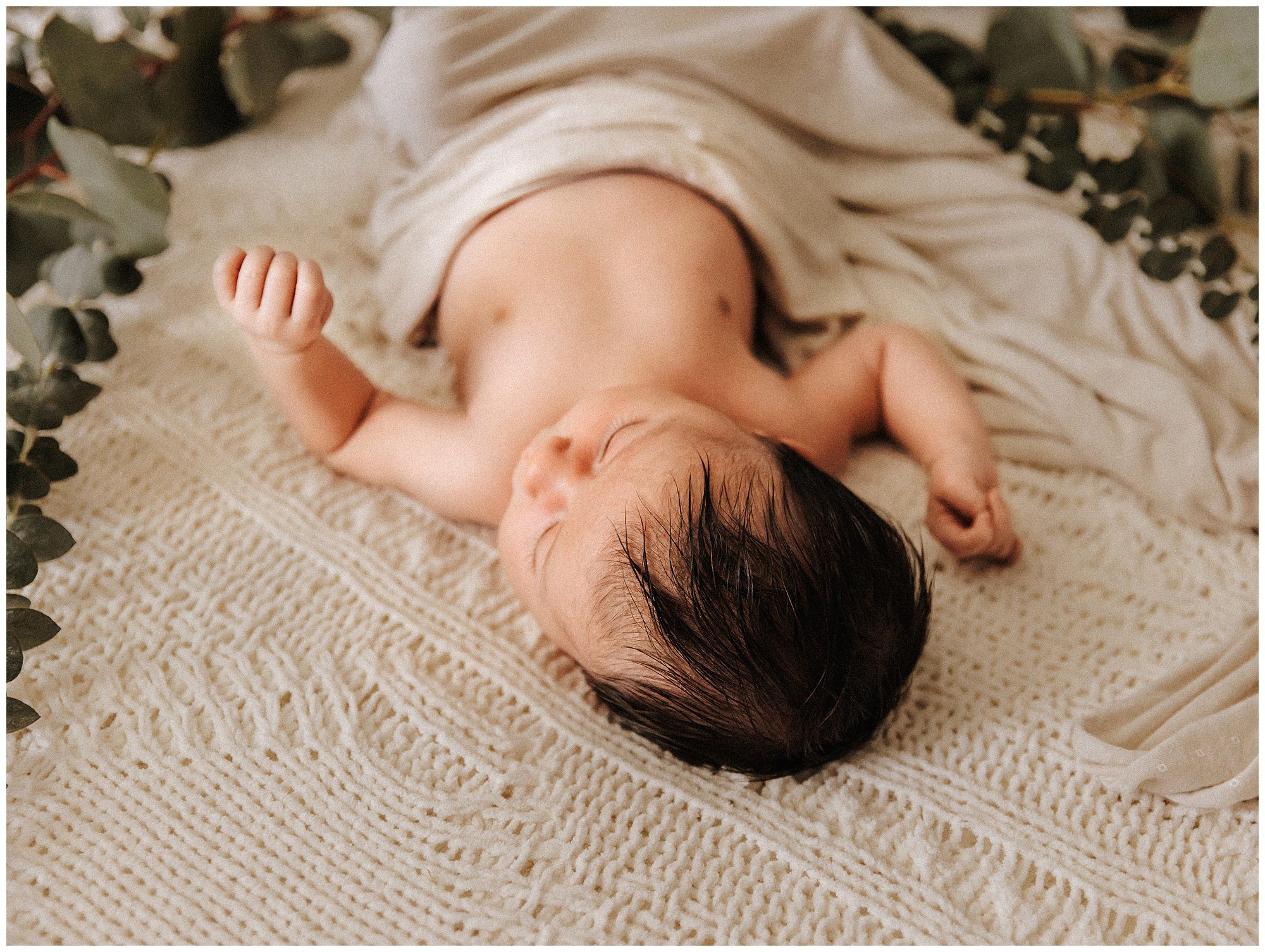 Newborn Baby Boy with Eucalyptus branches during lifestyle newborn session in murfreesboro