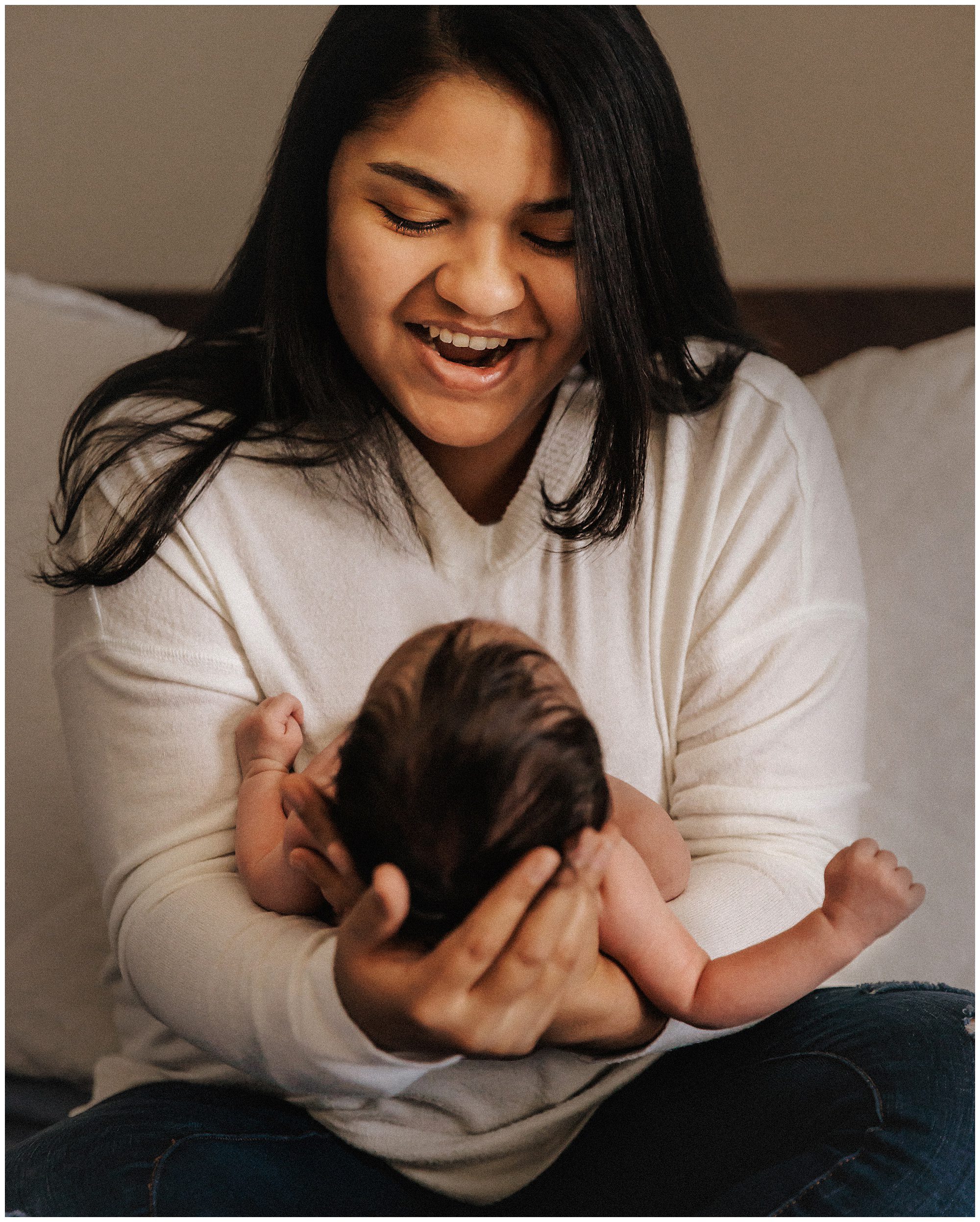Mother smiling at newborn son during in-home newborn session in Murfreesboro TN