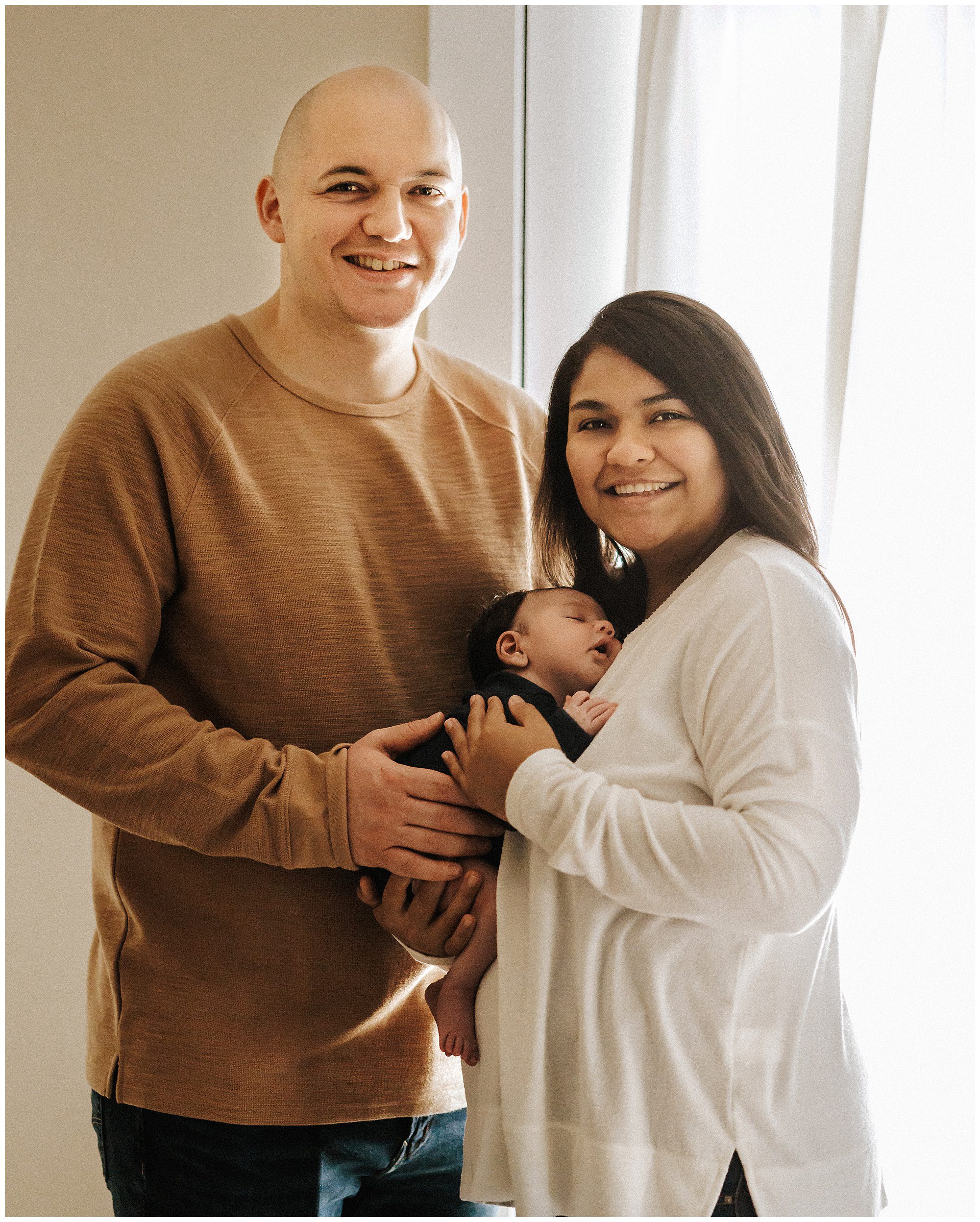 New parents holding newborn baby boy during in home newborn session near Nashville TN