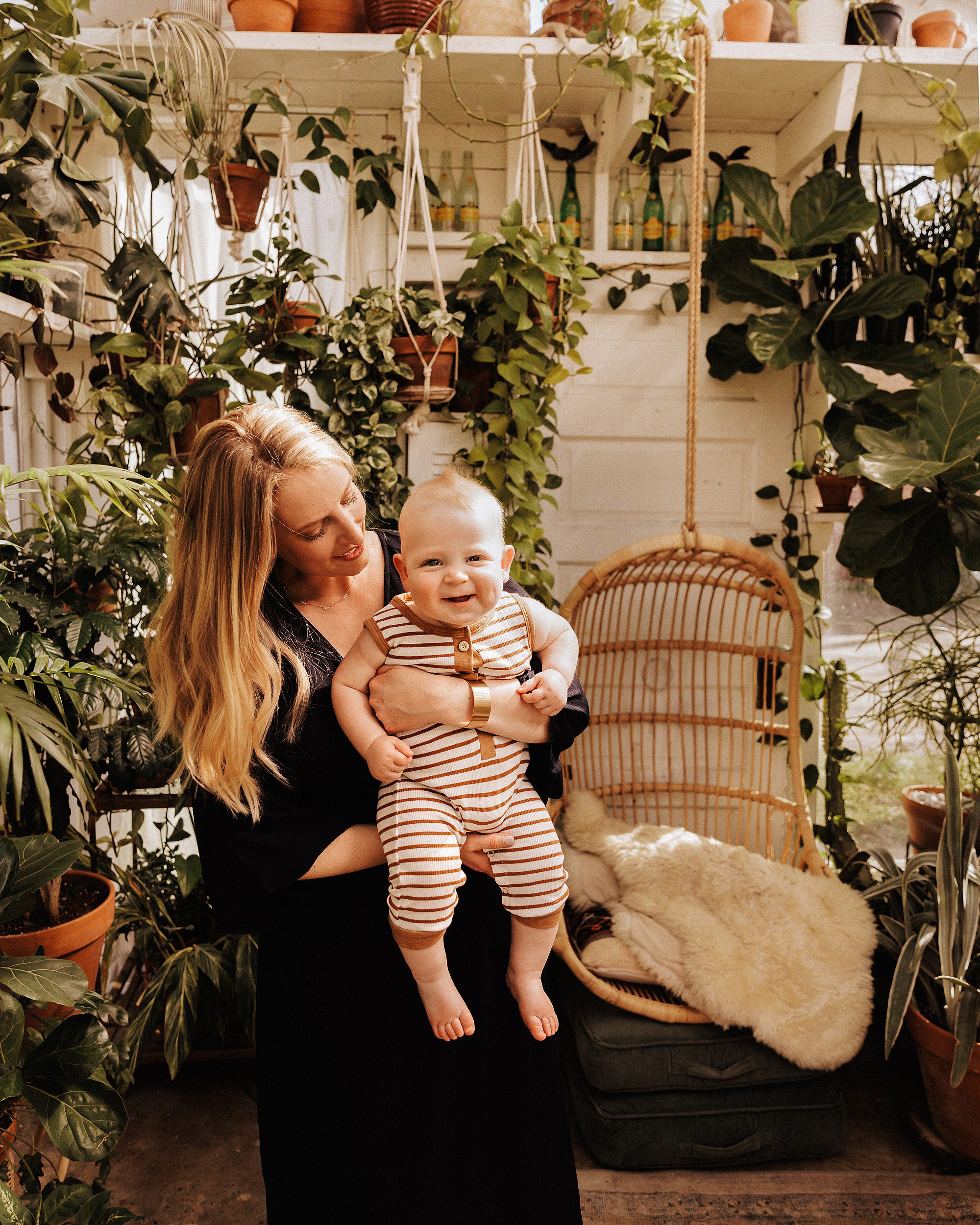 Mom holding her baby boy in a greenhouse during a mini session in Nashville