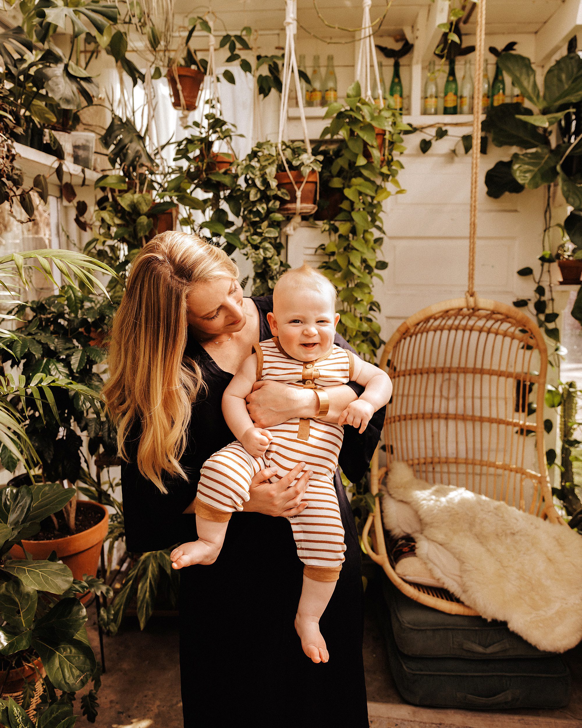 Mom holding her baby boy in a greenhouse during a mini session in Nashville
