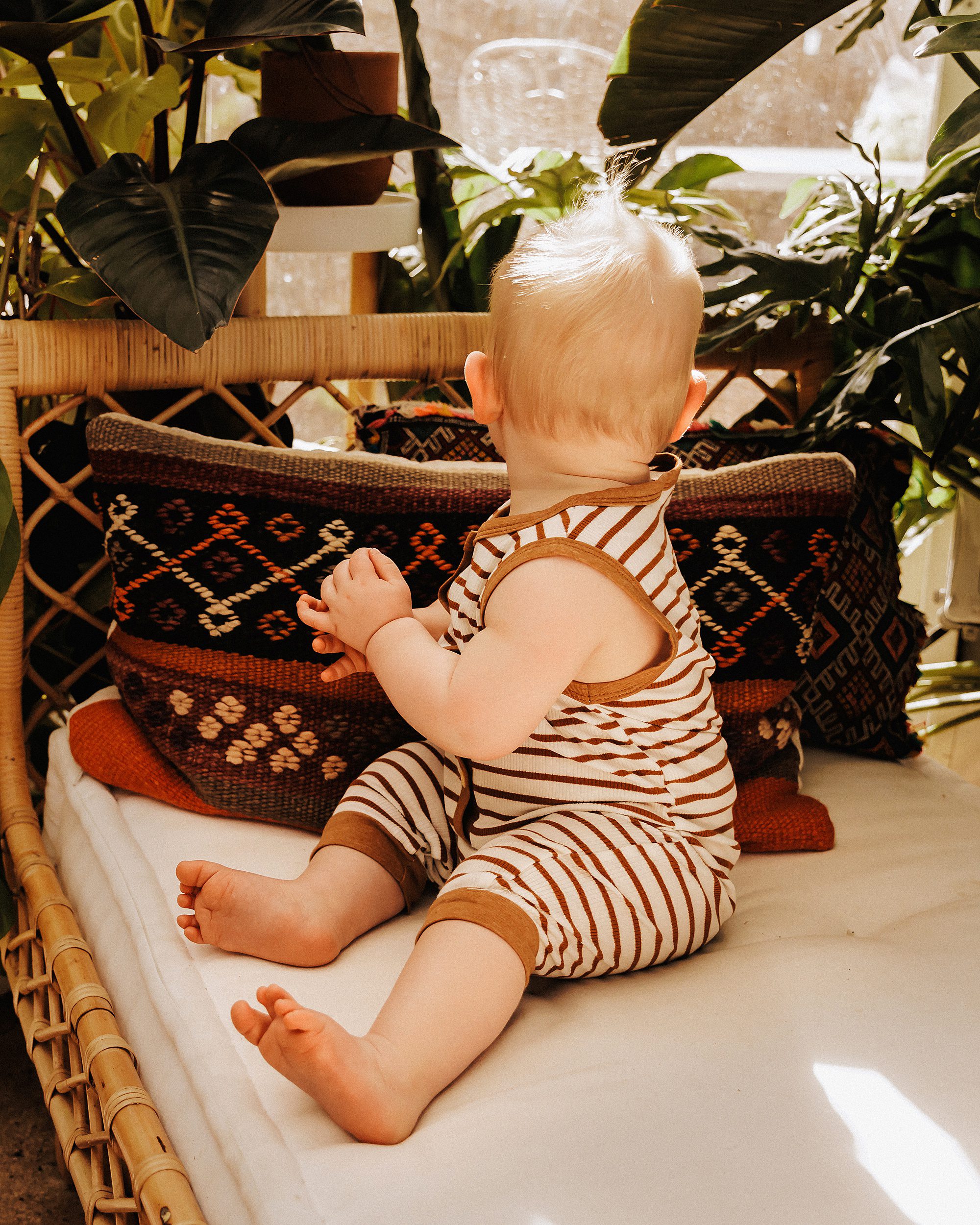10 month old sitting on rattan bench during a mini session in East Nashville