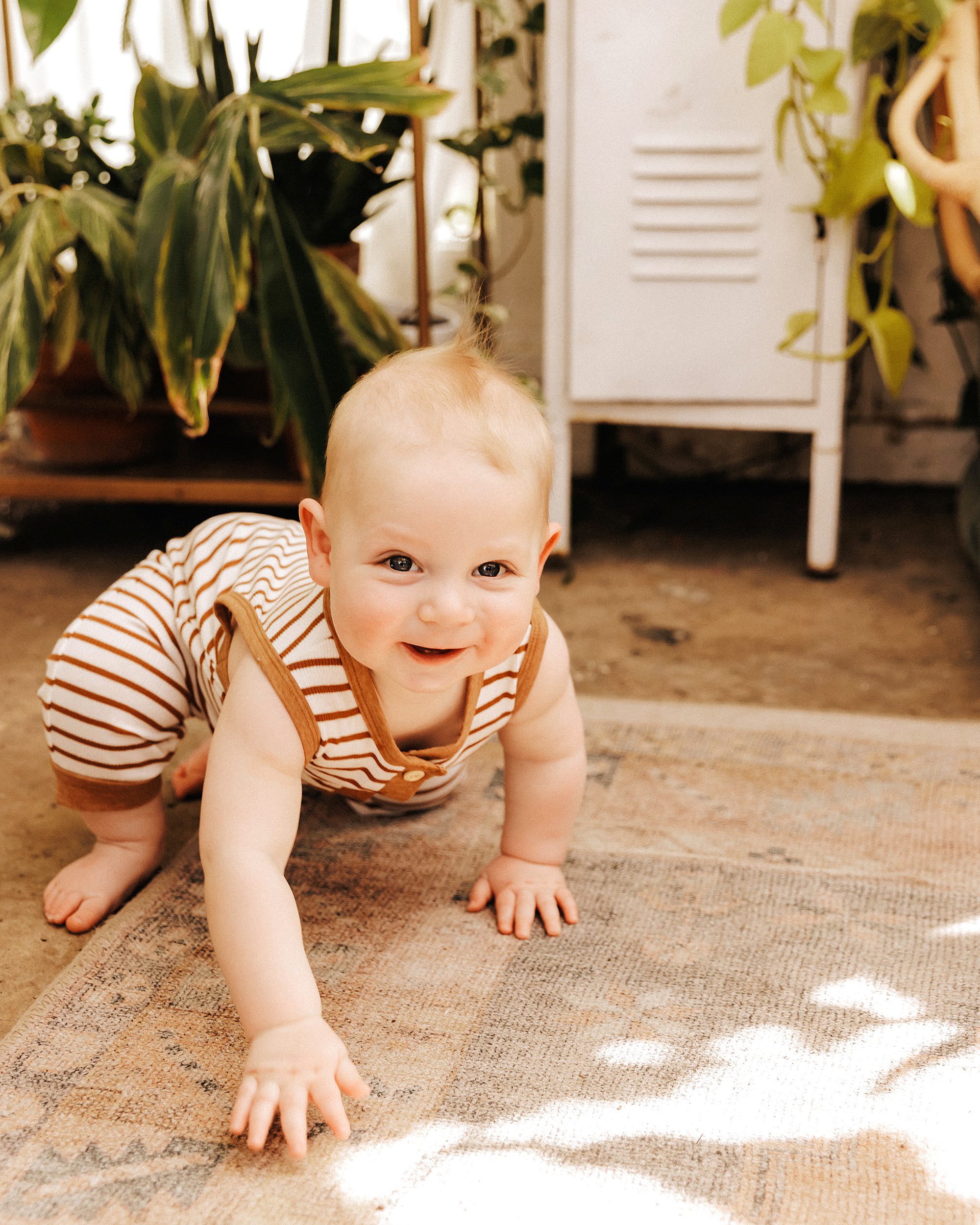 10 month old boy crawling during a mini session in East Nash Greenhouse
