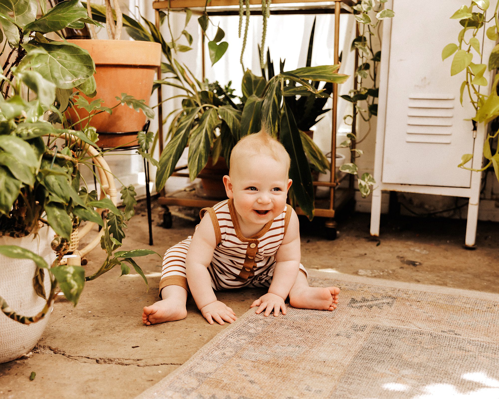 10 month old boy smiling at camera during a portrait session in Nashville