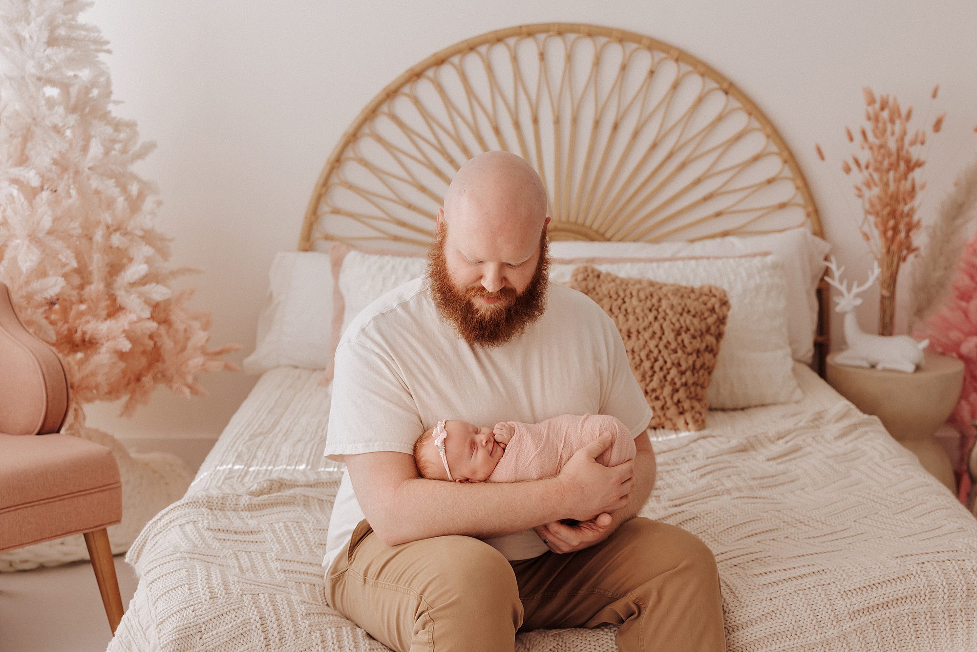 Daddy holds swaddled newborn baby girl