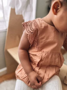 Baby girl wearing a Jamie Kay playsuit with lace sleeves