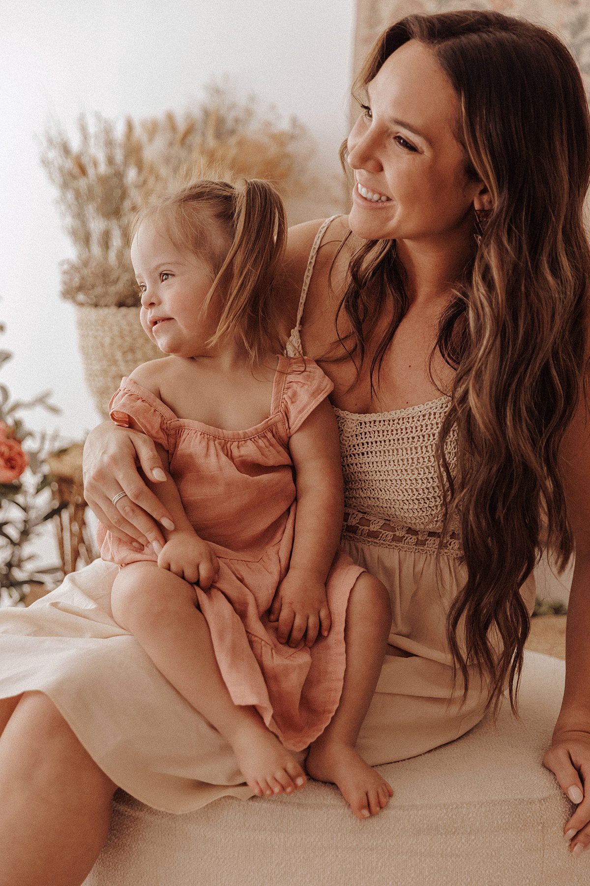 Mother and daughter smile while holding each other close for a photograph