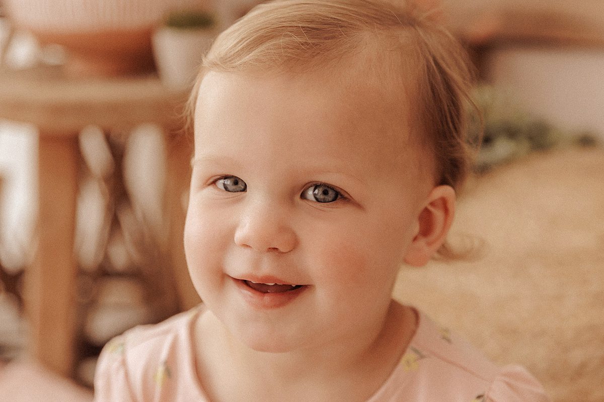 Little girl with fair skin and fair hair smiles at the camera