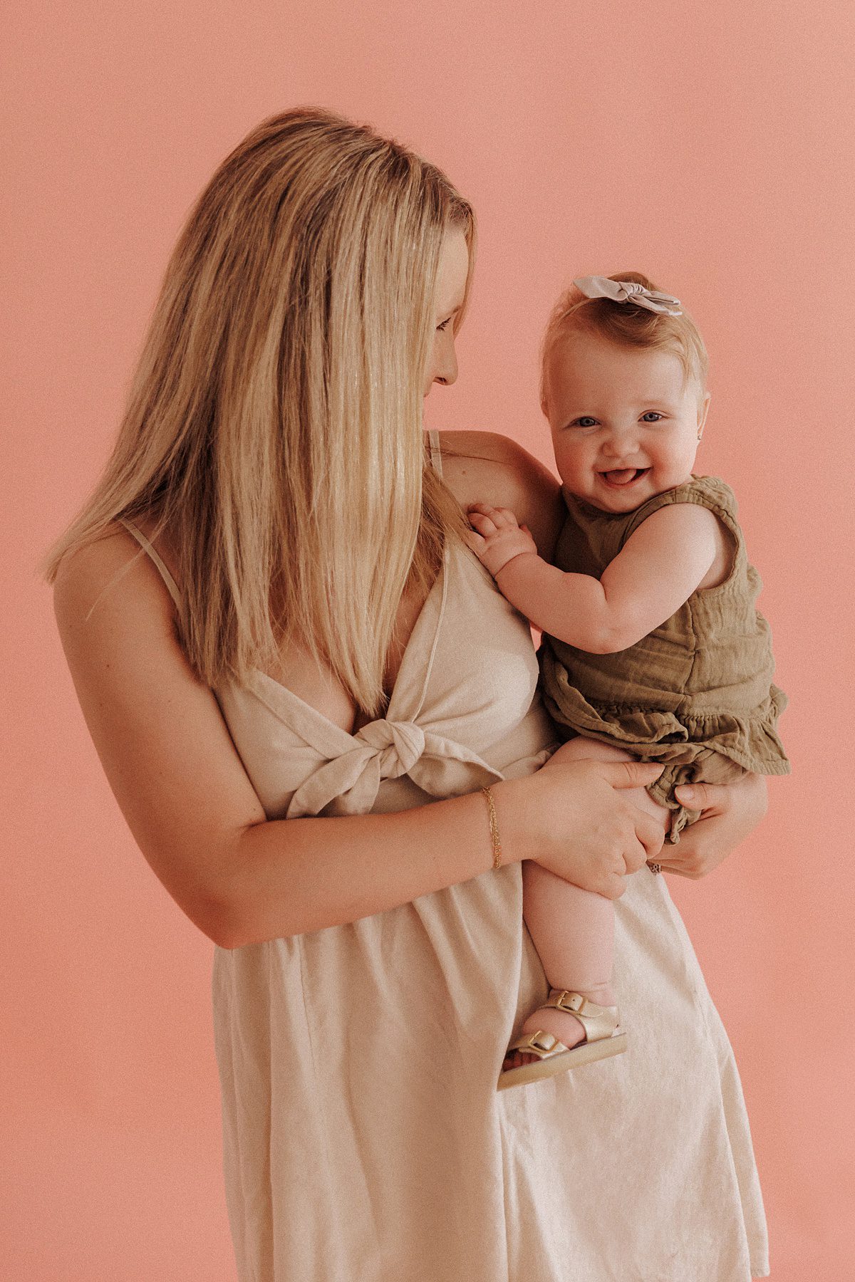 Motherhood photography pose of mom holding baby girl on her hip