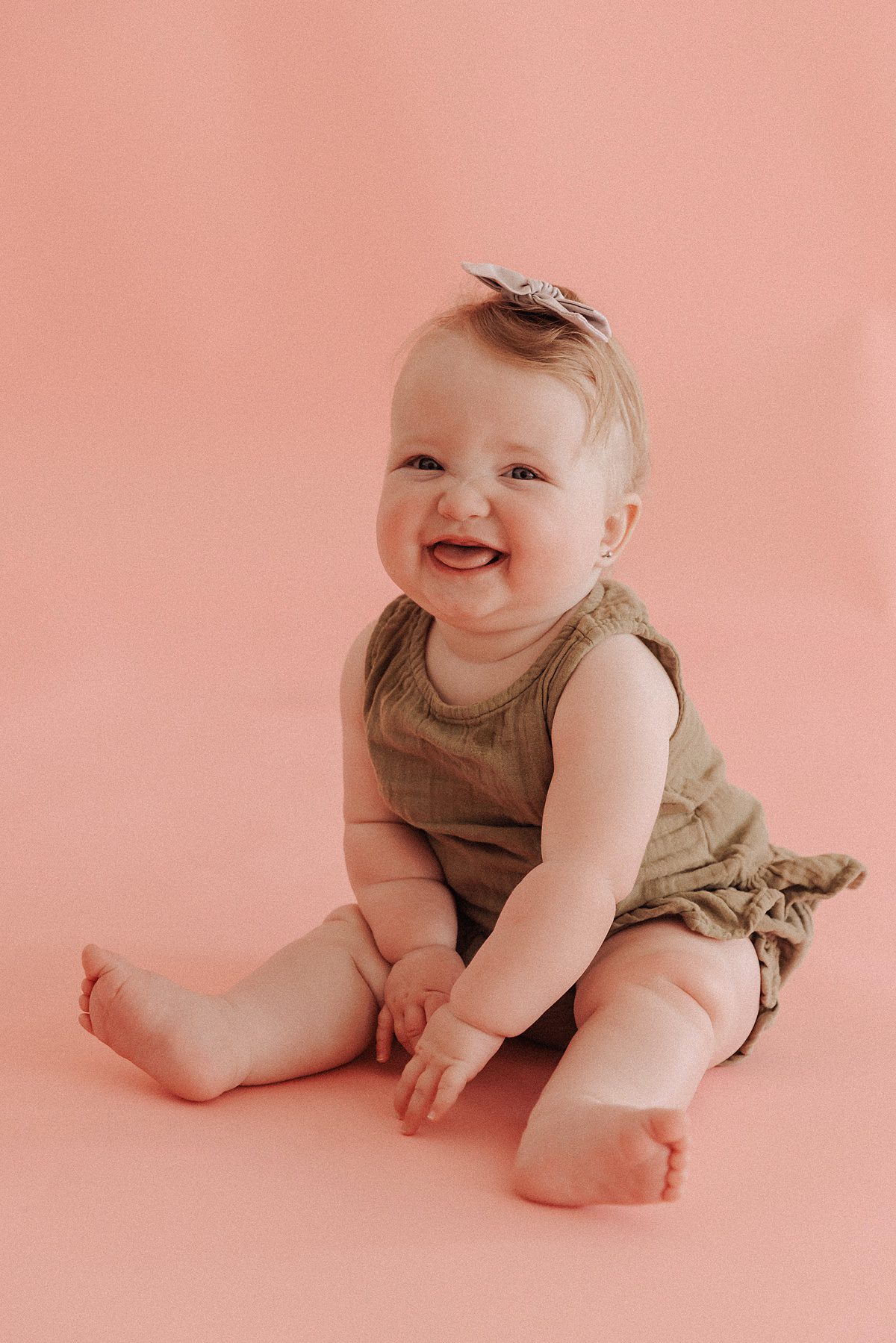 6 month old girl sitting up pose and laughing
