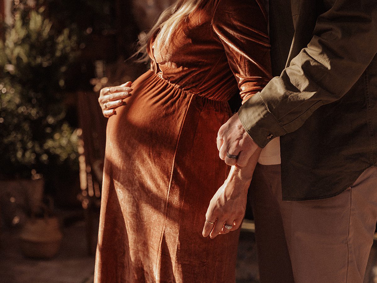 Pregnant belly in copper maternity dress