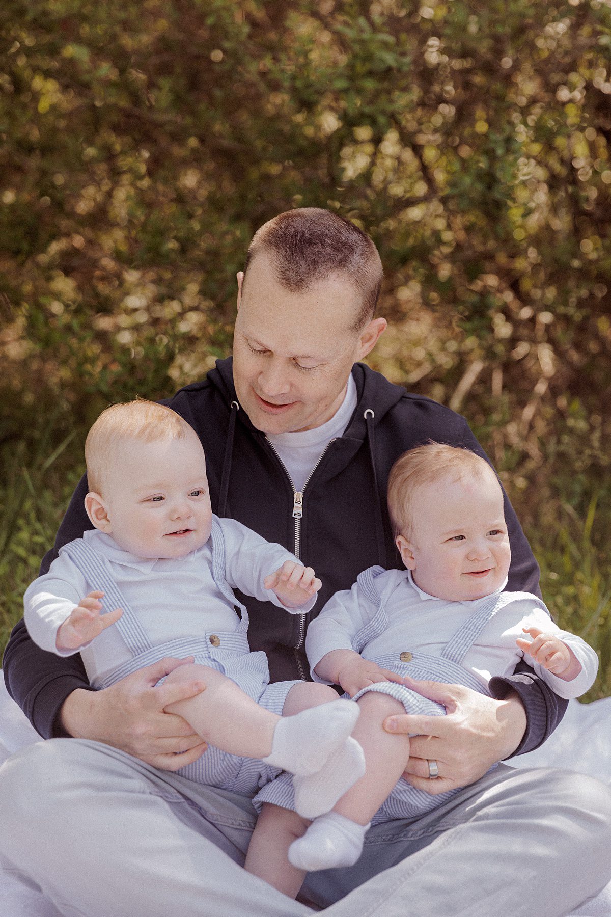Daddy and Me pose of father holding his infant twin sons